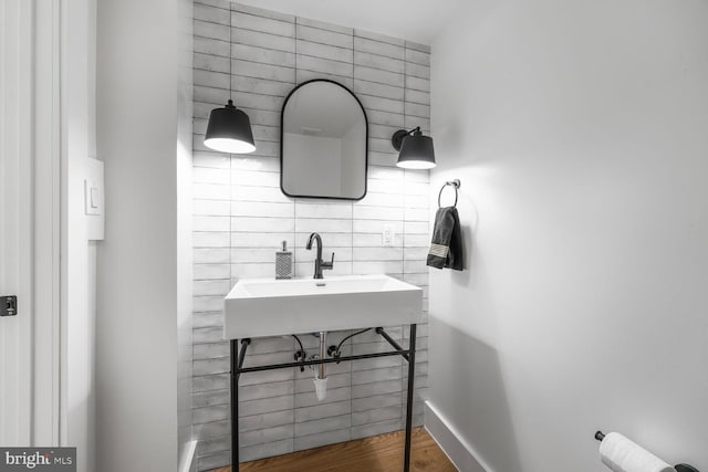 bathroom with wood finished floors, a sink, and baseboards