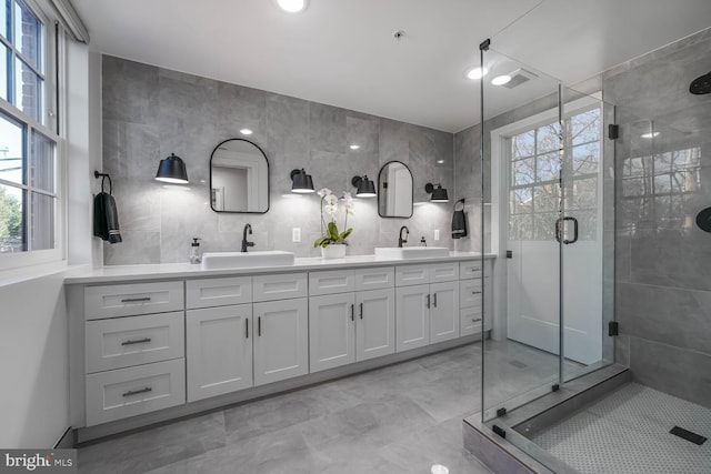 bathroom with plenty of natural light, tile walls, and a sink