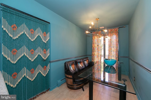 interior space with a notable chandelier, baseboard heating, and wood finished floors