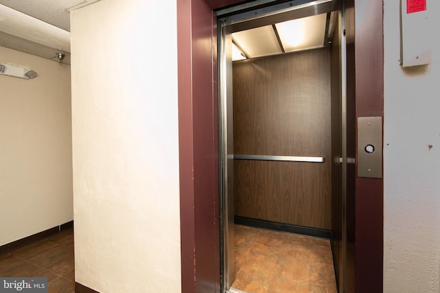 interior space with elevator and baseboards