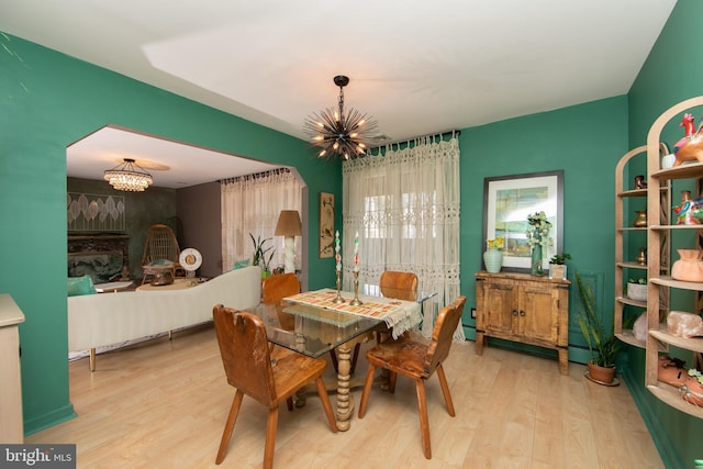 dining space featuring a baseboard radiator, a notable chandelier, and wood finished floors