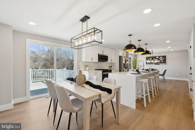 dining space featuring baseboards, recessed lighting, and light wood-style floors