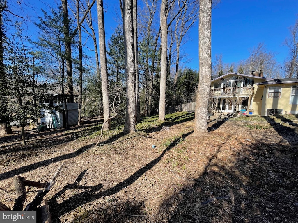 view of yard with a balcony and a shed