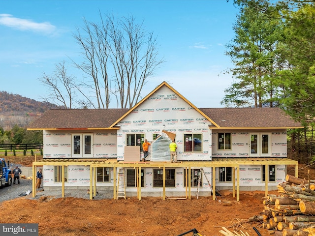 back of house featuring roof with shingles and fence