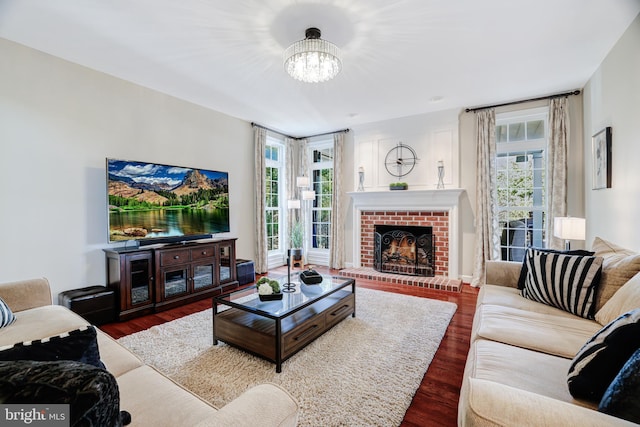 living area with plenty of natural light, wood finished floors, and a brick fireplace