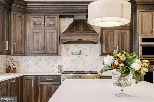 kitchen with light countertops, premium range hood, and dark brown cabinetry