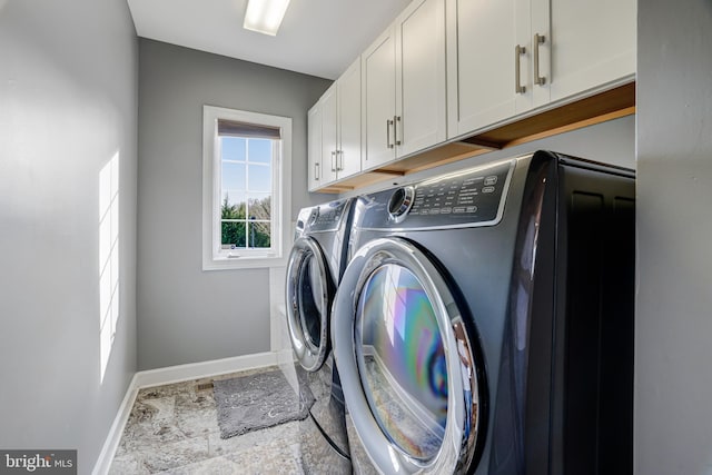 laundry room featuring baseboards, cabinet space, and washing machine and clothes dryer