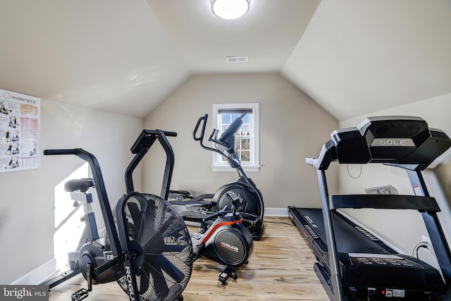 workout room with lofted ceiling, wood finished floors, visible vents, and baseboards