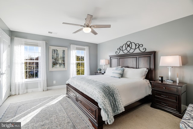 bedroom featuring light carpet, a ceiling fan, visible vents, and baseboards