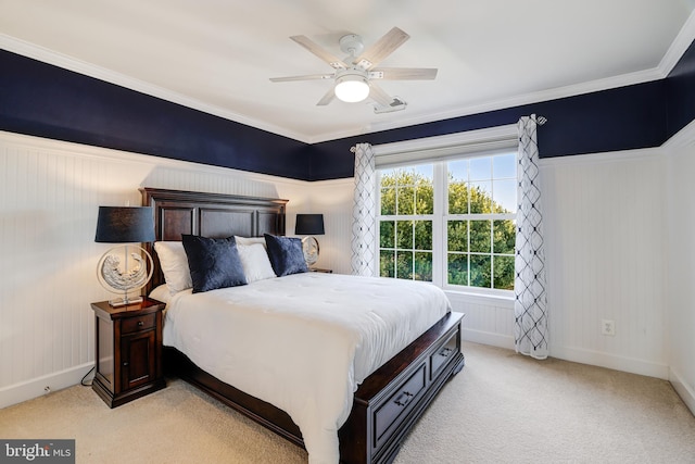 bedroom featuring light carpet, ornamental molding, and a ceiling fan