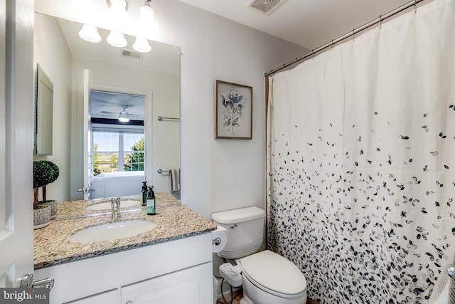 full bathroom with toilet, curtained shower, vanity, and visible vents