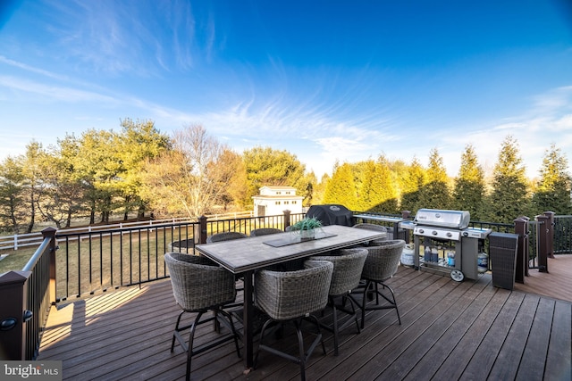 wooden terrace with outdoor dining area and grilling area