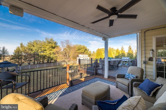 view of wooden balcony featuring outdoor lounge area, outdoor dining area, a ceiling fan, and a wooden deck