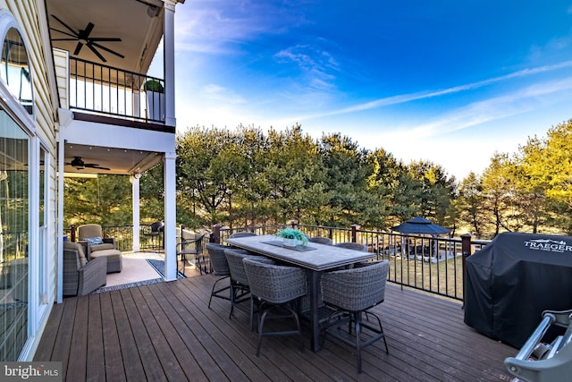 wooden terrace featuring outdoor dining area, a grill, and ceiling fan