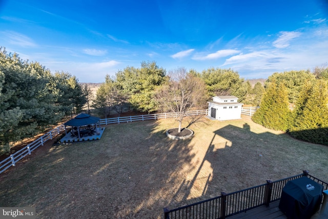 view of yard with a forest view, an outdoor structure, and a fenced backyard