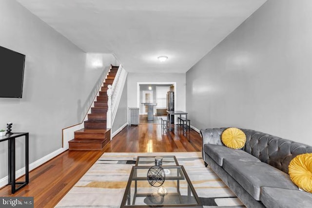 living area with stairway, wood finished floors, and baseboards