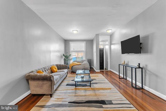 living room featuring radiator heating unit, wood finished floors, and baseboards