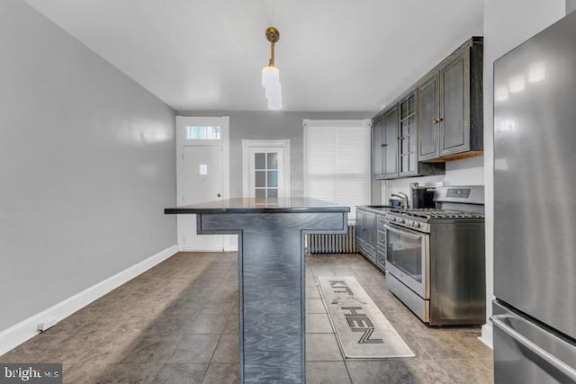 kitchen featuring pendant lighting, stainless steel appliances, dark countertops, a kitchen island, and a kitchen breakfast bar