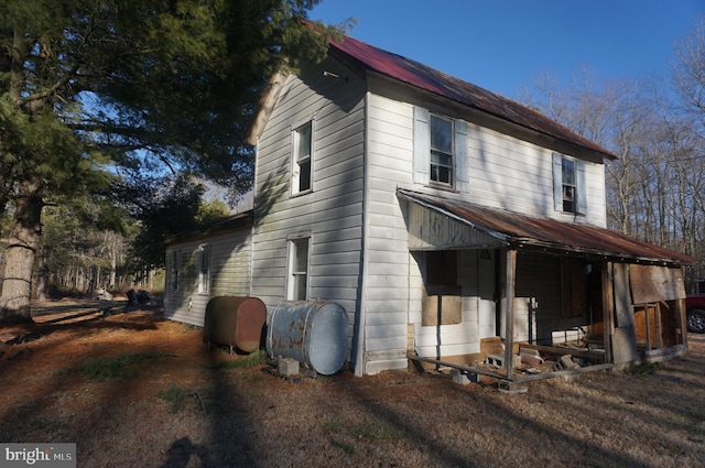 view of side of home featuring heating fuel and metal roof