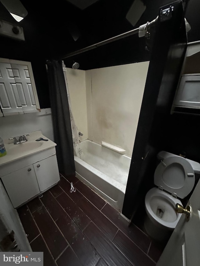 full bath featuring wood tiled floor, vanity, toilet, and shower / bath combo with shower curtain