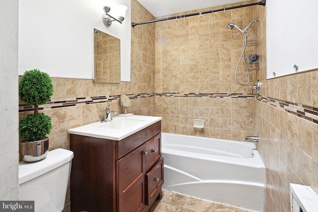 bathroom featuring shower / tub combination, toilet, a wainscoted wall, vanity, and tile walls