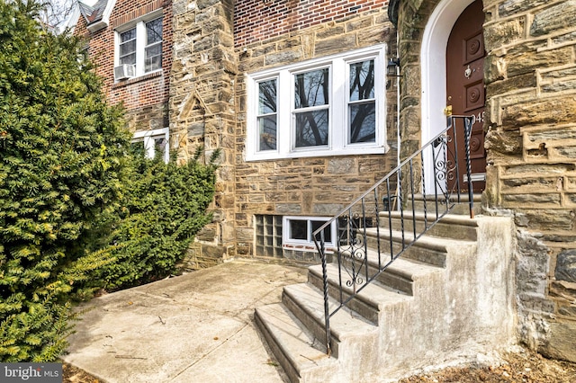 property entrance featuring stone siding and brick siding