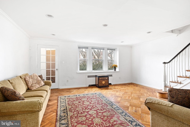 living room featuring stairs, radiator heating unit, baseboards, and crown molding