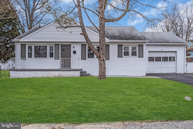 view of front facade with a shingled roof, a front yard, driveway, and an attached garage