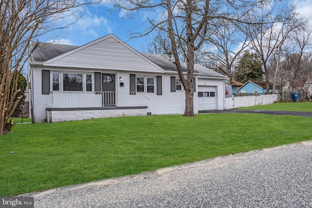 view of front facade with an attached garage, fence, a front lawn, and aphalt driveway