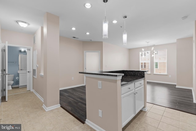 kitchen featuring light tile patterned floors, white cabinets, dark countertops, decorative light fixtures, and recessed lighting