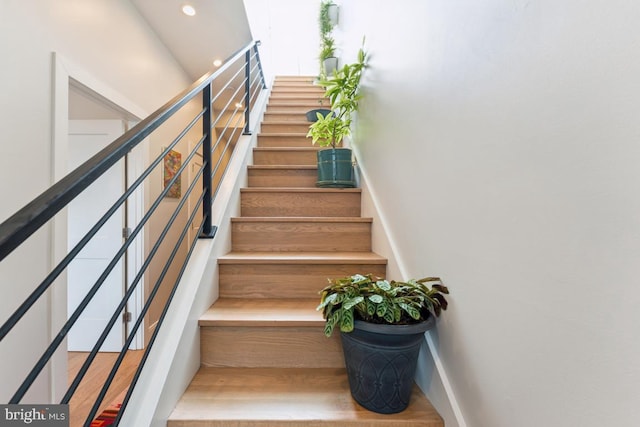 staircase with recessed lighting and wood finished floors