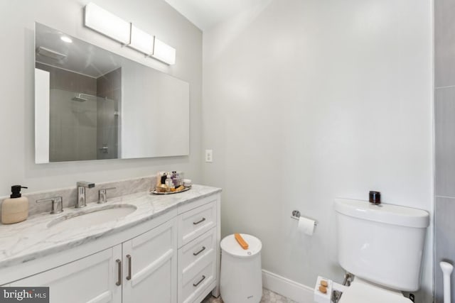 full bathroom with vanity, baseboards, a tile shower, and toilet