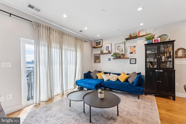 living room featuring recessed lighting, baseboards, visible vents, and light wood-type flooring