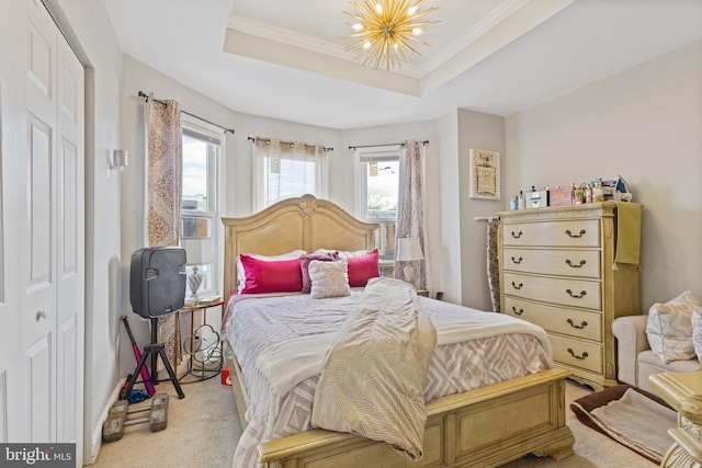 bedroom featuring a chandelier, a tray ceiling, carpet flooring, and crown molding