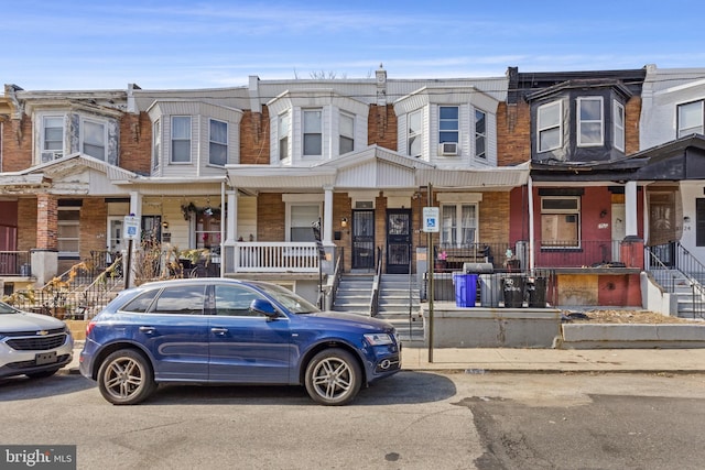 townhome / multi-family property featuring cooling unit and covered porch