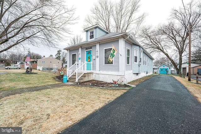 bungalow-style home featuring driveway and a front yard