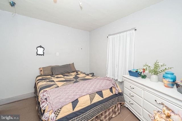 bedroom with baseboards and wood finished floors