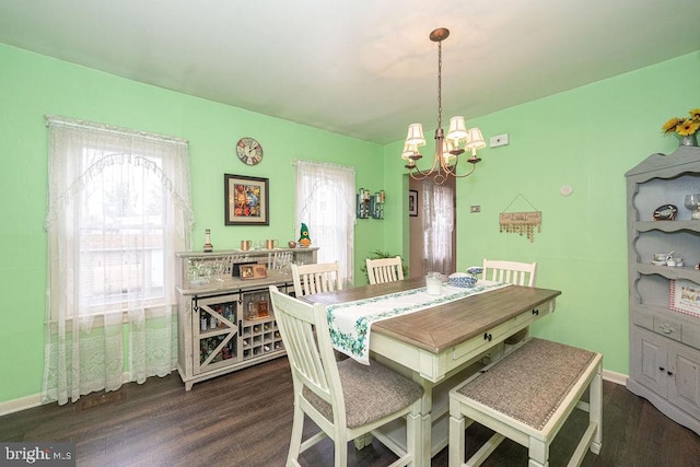 dining room with a chandelier, dark wood-style flooring, plenty of natural light, and baseboards