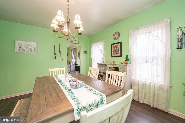 dining area featuring a chandelier, dark wood-type flooring, and a wealth of natural light