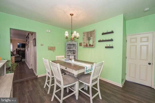 dining area featuring dark wood-style floors, baseboards, and an inviting chandelier