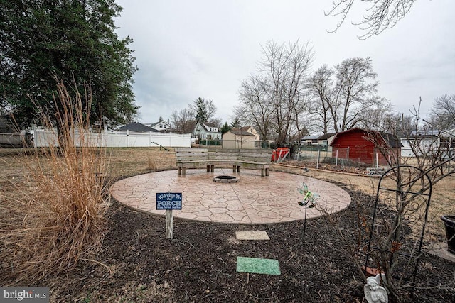 view of yard featuring a residential view, fence, a fire pit, and a patio