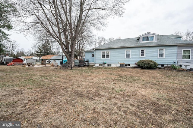 rear view of property featuring a yard