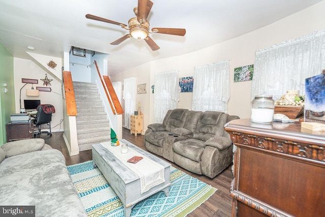 living area featuring stairs, ceiling fan, and wood finished floors