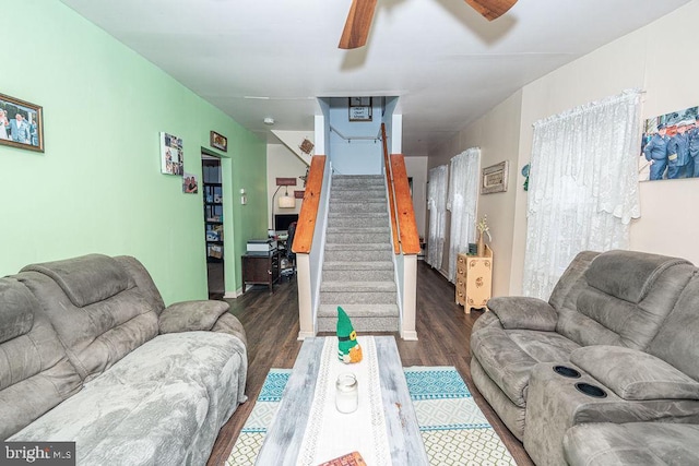 living room with stairs, a ceiling fan, and wood finished floors