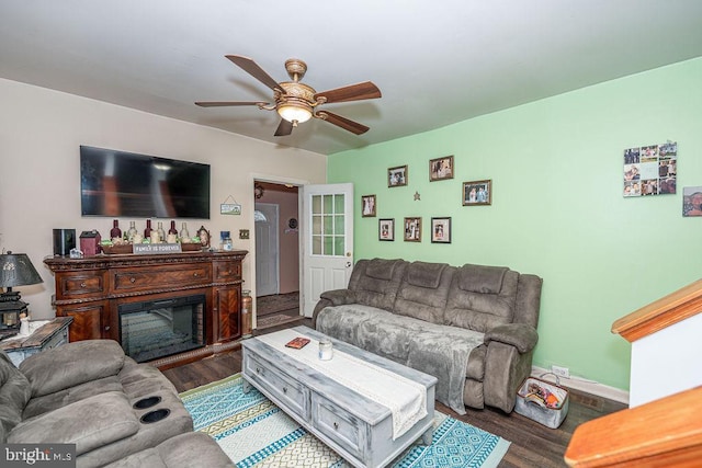 living room featuring a fireplace, wood finished floors, and a ceiling fan