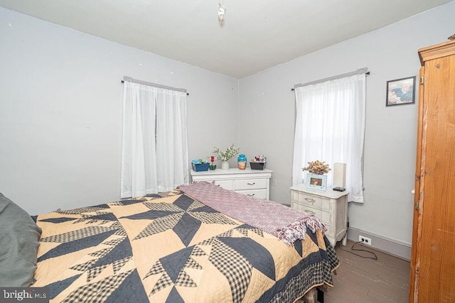 bedroom with baseboards and wood finished floors