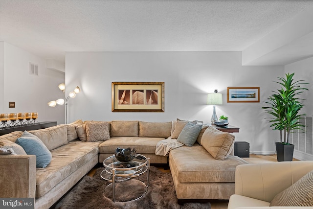 living room featuring a textured ceiling, visible vents, and baseboards