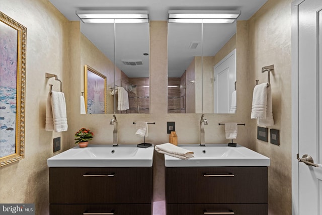 full bath featuring tasteful backsplash, two vanities, and a sink