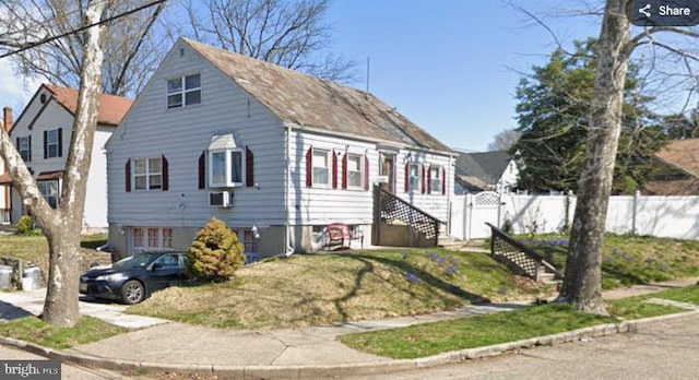 view of front of house featuring fence and a front lawn