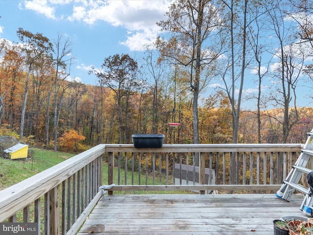 wooden terrace featuring a view of trees